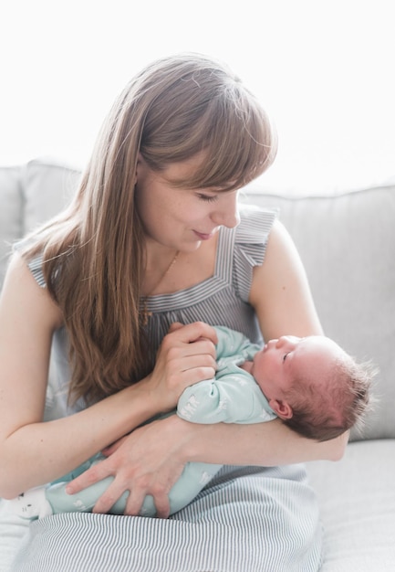 若い母親と彼女の新生児、3週齢の娘のライフスタイルの肖像画。