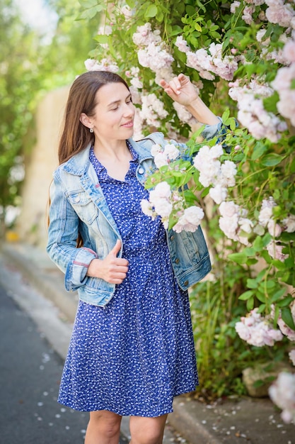 Ritratto di stile di vita di giovane donna alla moda che soggiorna per strada nella città vecchia