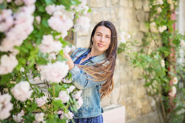 Ritratto di stile di vita di giovane donna alla moda che soggiorna per strada nella città vecchia