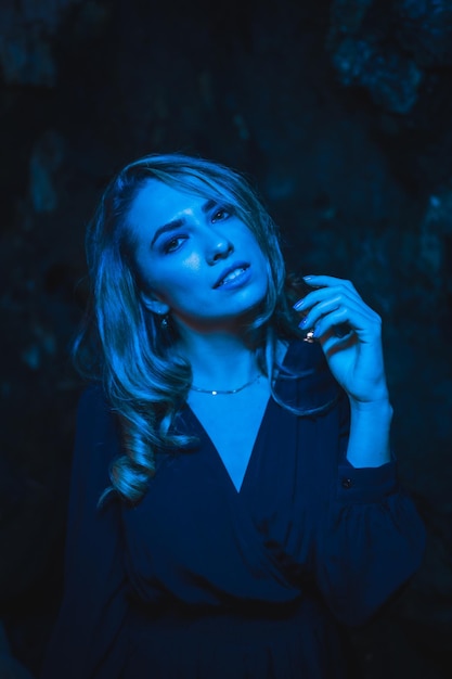 Lifestyle-portret van een blank meisje in een grot met blauw led-licht