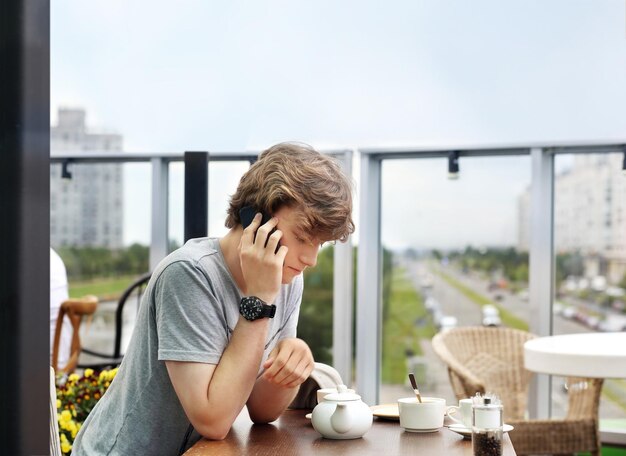 Lifestyle portret van een jonge man die buiten een smartphone gebruikt