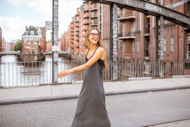 Lifestyle-portret van een stijlvolle zakenvrouw die op de ijzeren brug in Hamburg, Duitsland loopt