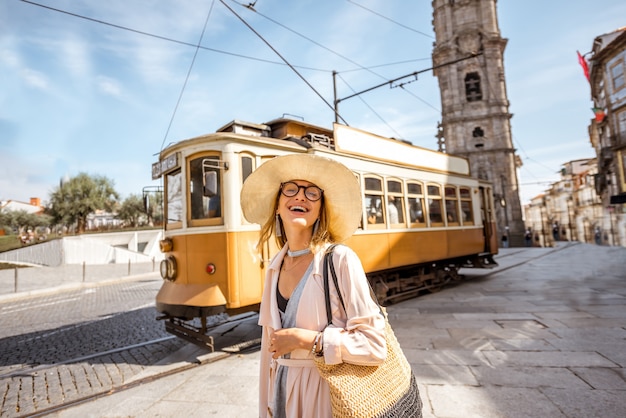 Lifestyle-portret van een vrouw in de buurt van de beroemde oude toeristische tram op straat in de stad Porto, Portugal