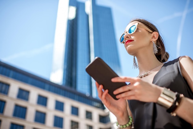 Lifestyle portret van een zakenvrouw met telefoon in de moderne wijk in de stad Frankfurt