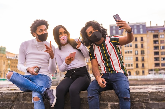 Foto stile di vita, selfie di tre amici per strada con maschere facciali.