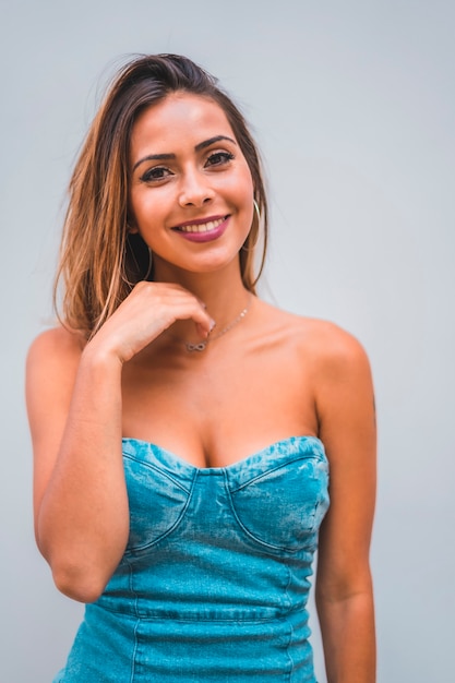 Lifestyle session, a young caucasian brunette smiling on a plain gray background