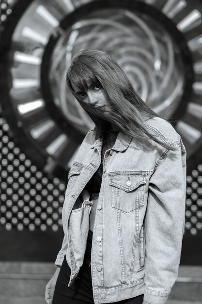 Lifestyle shot of alluring young woman with red lips wears jeans jacket. Monochrome color