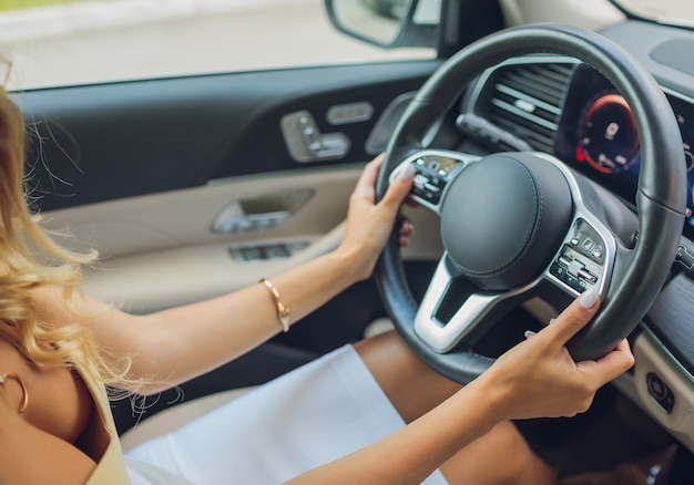 Lifestyle shot van jonge vrolijke vrouw die auto achteraanzicht rijdt