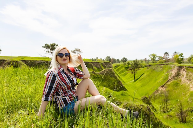 가방을 꾸리고 여행을 즐기고 즐기는 금발 힙스터 여성의 라이프스타일 여름 이미지, 세련되고 신선한 모습, 행복한 분위기, 밝은 색상, 여행 컨셉, 감정.