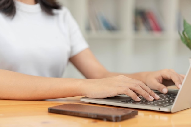 Lifestyle and technology concept young asian woman using laptop and smartphone to working at home