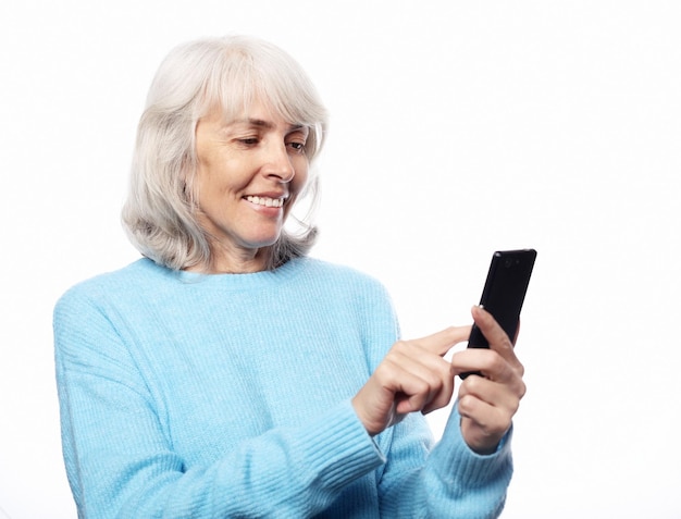 Lifestyle tehnology en mensen concept oudere vrouw met smartphone sms geïsoleerd op witte achtergrond