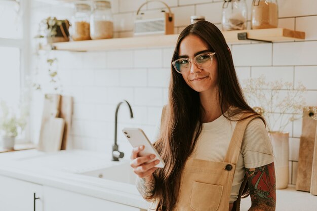 Lifestyleblogger met haar mobiele telefoon in de keuken