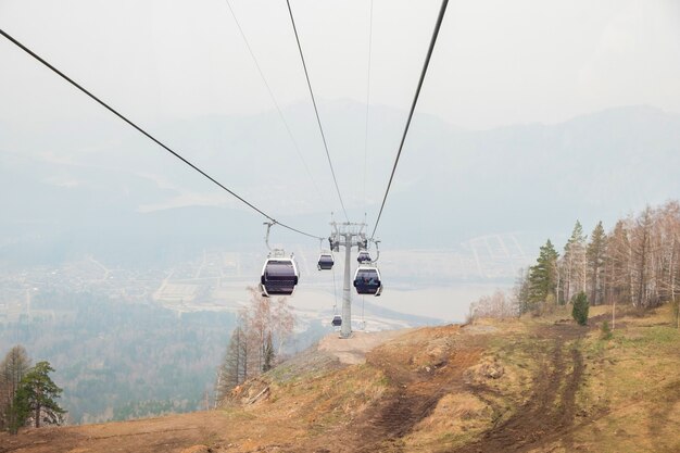 Liftcabines in een bergskigebied skilift kabelbaan op hilghland berg wintertoevlucht op bewolkte dag ski stoeltjeslift kabelbaan met mensen schilderachtig panoramisch weids uitzicht op afdalingen