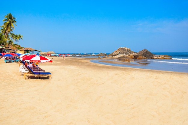 Ligbedden met parasols op het strand van Vagator of Ozran in het noorden van Goa, India