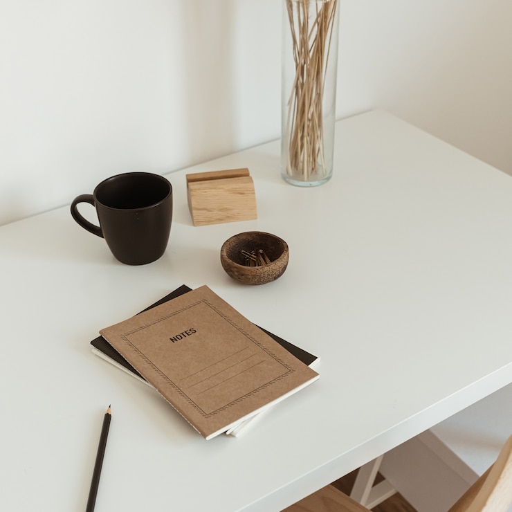 Photo light aesthetic hygge space with wooden chair, table, reed pampas grass bouquet, mug, notebook