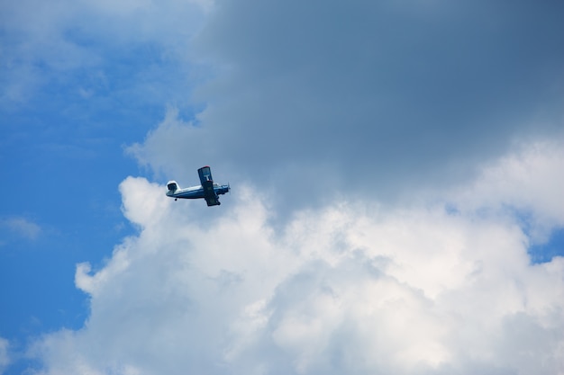 美しい対照的な雲の中の軽飛行機