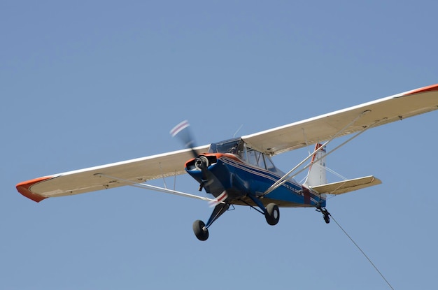 Photo light aircraft flying propeller plane flying towing ultralight glider