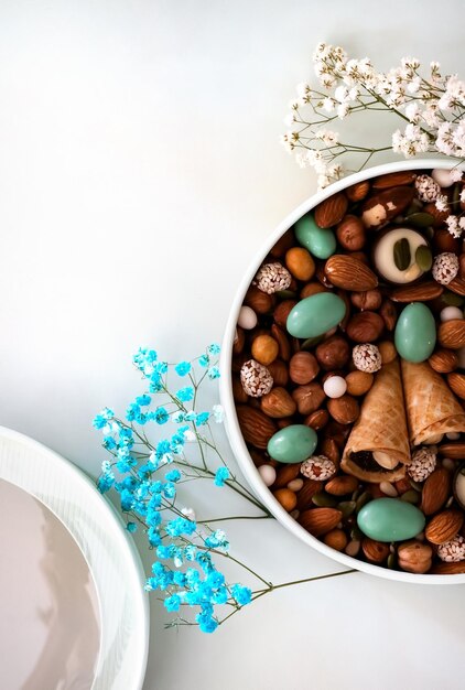 Foto su uno sfondo chiaro c'è una scatola rotonda piena di varie noci e frutta secca giorno delle madri giorno di san valentino giorno internazionale della donna un regalo delizioso cibo a basso contenuto di grassi