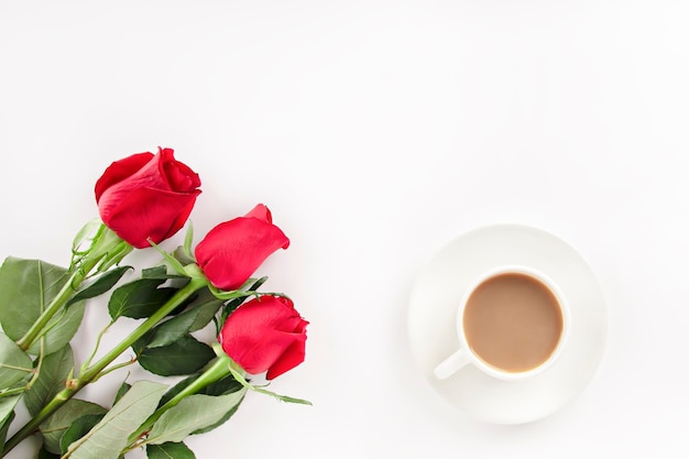 on a light background three roses and a mug with coffee