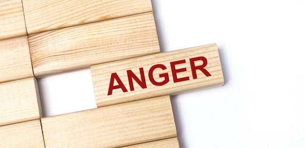 On a light background wooden blocks with the text ANGER Closeup top view