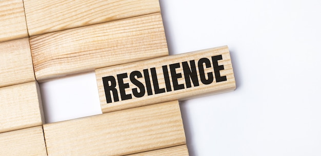 明るい背景に、RESILIENCEというテキストが付いた木製のブロック。クローズアップ上面図。