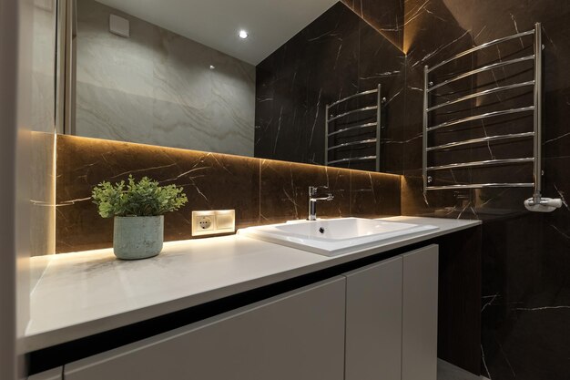 Light beige and brown modern bathroom interior with bath and shower and white cabinet with mirror