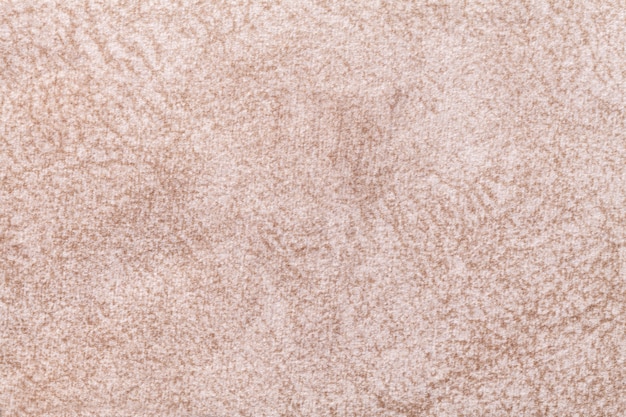 Light beige fluffy background of soft, fleecy cloth. Texture of textile closeup.