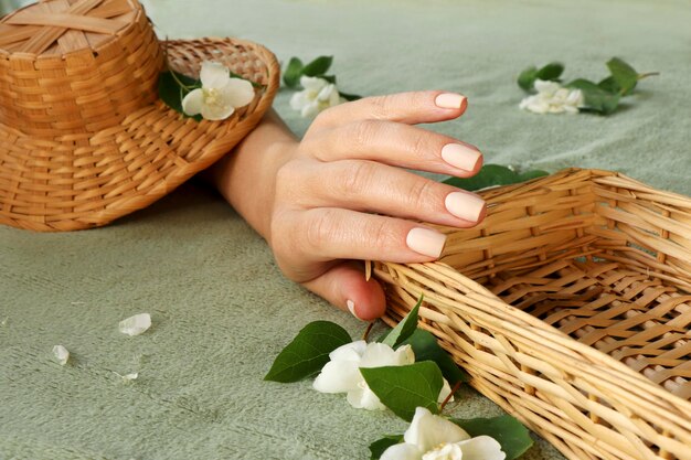 Light beige manicure on short nails with jasmine flowers