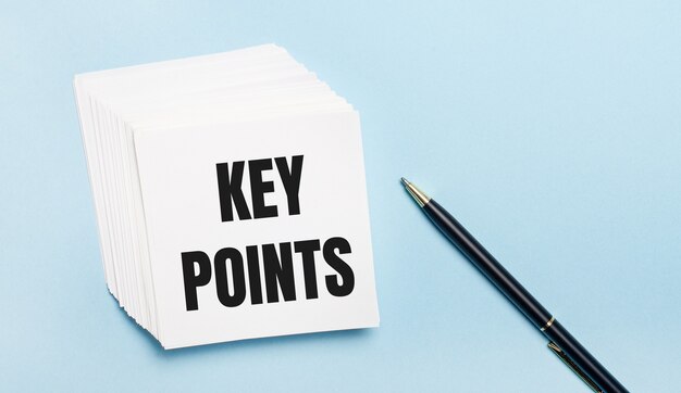 On a light blue background, there is a black pen and a stack of white note paper with the text KEY POINTS