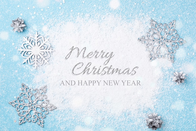 Light blue Christmas greeting card. Snow and snowflakes.