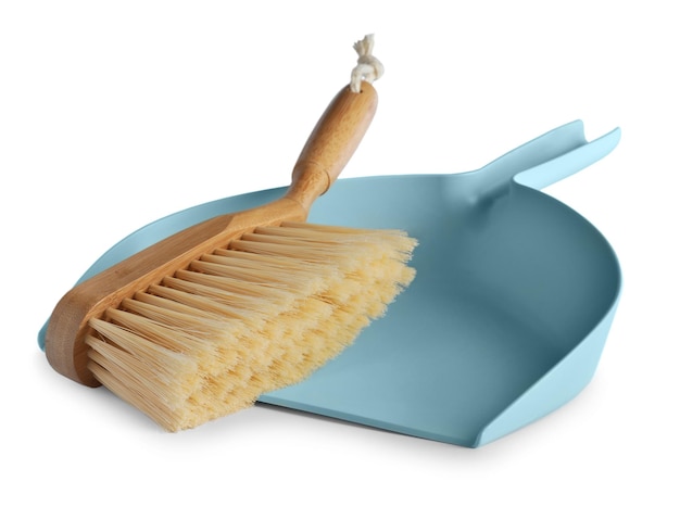 Photo light blue dustpan and wooden brush on white background