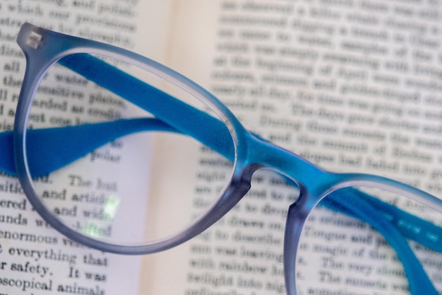 Light blue reading glasses isolated on a book