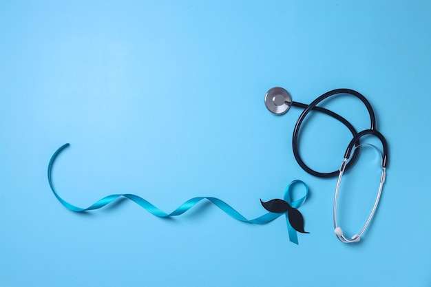 Light blue ribbon with mustache and stethoscope isolated on blue background