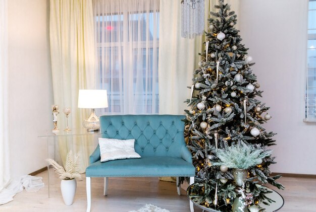 Light and blue room with Christmas and New Year decorated interior. Christmas tree  in a light interior of the house.Photo