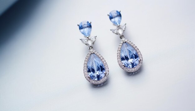 Photo light blue sapphires dangling from blue earrings on white background