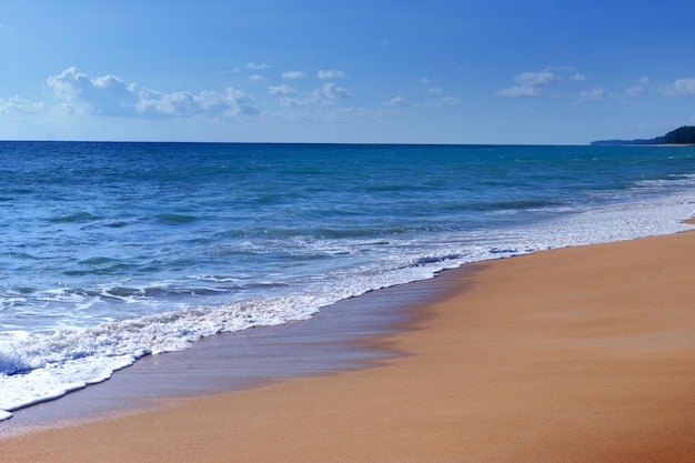 Light blue sea waves and island on clean sandy beach Tropical white sand beach and soft sunshine background