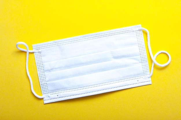 Photo light blue sterile face mask on yellow background