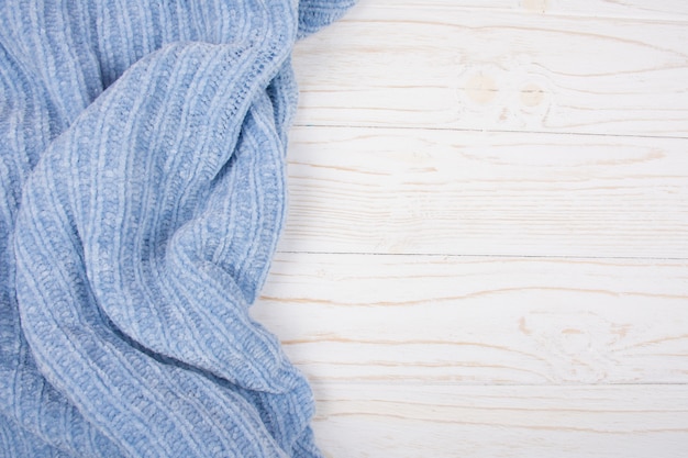 Light blue wool fabric on a white wooden background