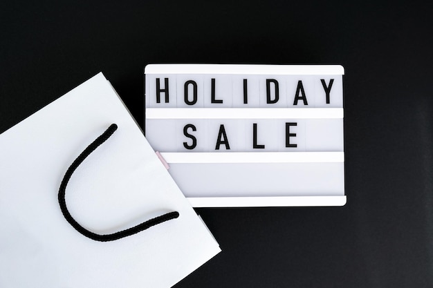 Photo light board with text holiday sale with paper shopping bags big sale online shopping concept