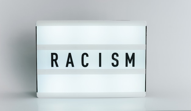 Photo light box with the headline racism with copyspace, over white background