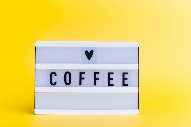 light box with text, COFFEE, on yellow wall