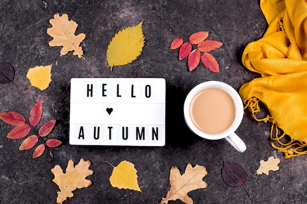 Light box with words Hello Autumn, cup of coffee and colorful autumn fall leaves