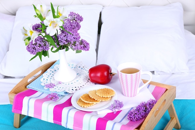 Light breakfast and beautiful bouquet on bed