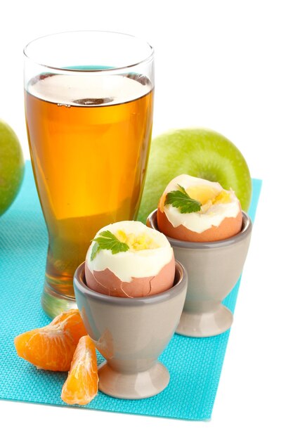 Light breakfast with boiled eggs and glass of juice isolated on white