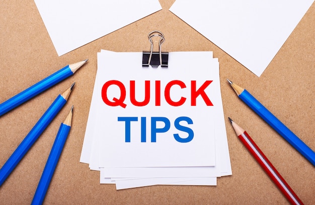 On a light brown background, blue and red pencils and white paper with the text QUICK TIPS