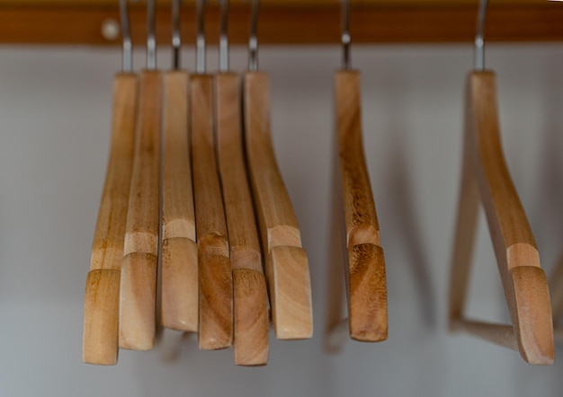 Light brown wood hangers lined up inside a wardrobe