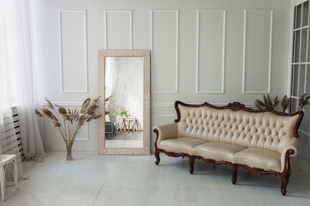 Light brown wooden mirror with ethnic pattern in a bright room with white walls