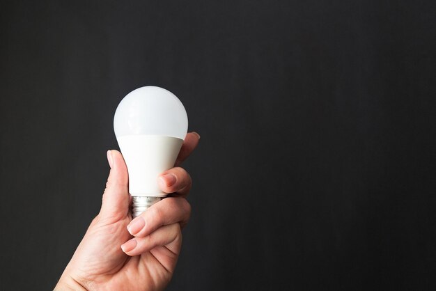 Light bulb in hand on a black background