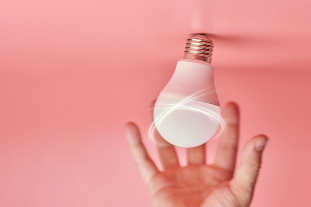 電球と手、アイデアをキャッチするコンセプト。新しいイベントのシンボルまたは問題の解決策の発見。創造的な最小限の革新。