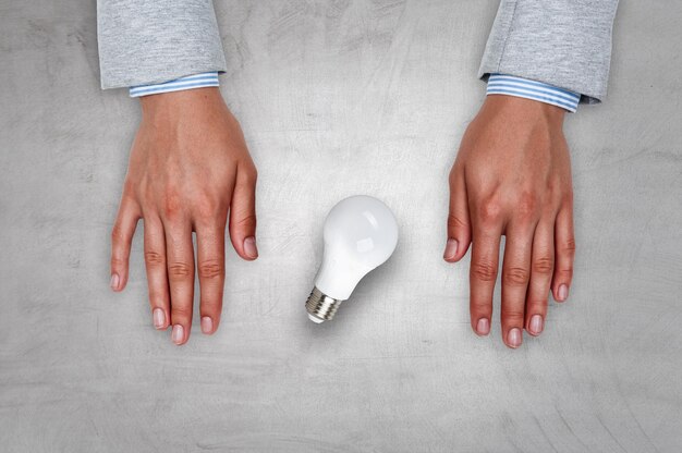 Light bulb between hands. mixed media